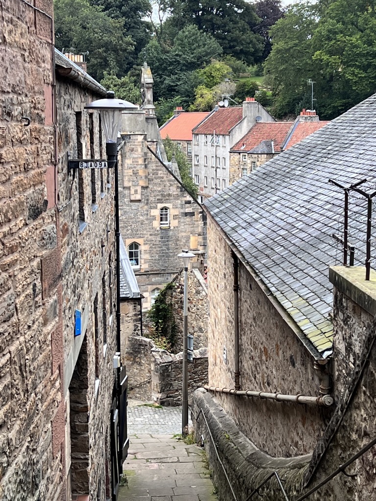 Narrow downhill walkway through historic stone Dean Village